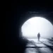 Silhouette person walking dark tunnel