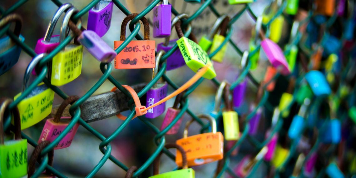 green chain link fence with assorted color padlocks