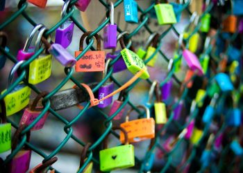 green chain link fence with assorted color padlocks